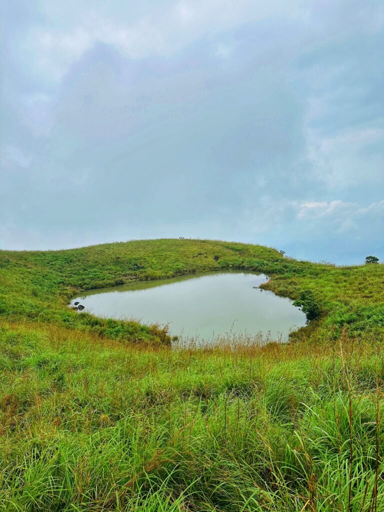 Scenic view of a heart-shaped lake in the lush green hills of Wayanad, Kerala, India.
